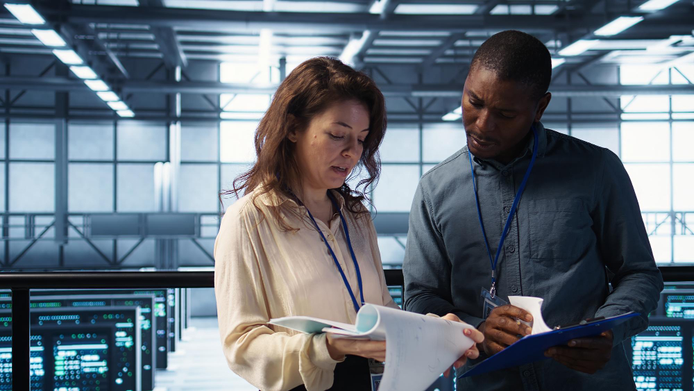 Mission-Critical Trust — engineers reviewing documentation in a data-centre walkway